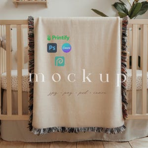 May include: A beige baby blanket with fringe trim, draped over a white crib with a white and black polka dot sheet. The blanket has the text "mockup" and the logos for Printify, Photoshop, Canva, and a generic logo with a "P" in a circle.