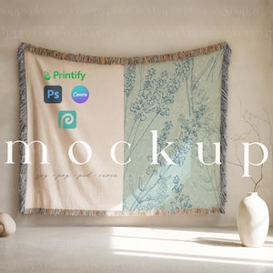 May include: A mockup of a woven throw blanket with a floral design. The blanket is draped over a wall and has a fringe border. The design features a light green background with blue floral illustrations. The text "mockup" is printed on the blanket, along with the text "jpg - png - psd - canva".