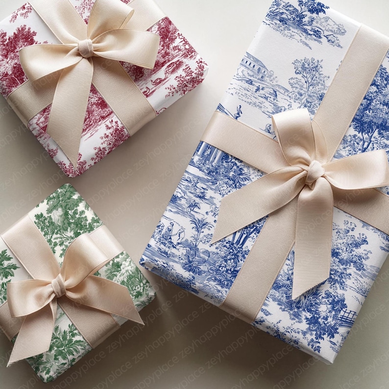 May include: Four wrapped gifts with cream-colored bows. The wrapping paper features various patterns: a red toile, a blue toile, and a green toile. The gifts are arranged on a neutral surface.