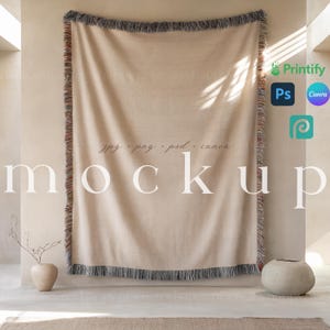 May include: A beige tapestry with fringe hanging on a wall. The tapestry is a mockup for a design project. The text "jpg, png, psd, canva" is written on the tapestry. The text "mockup" is written below the tapestry.