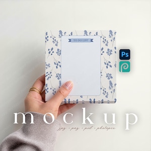 Può includere: Un blocco note con un motivo floreale blu e bianco, tenuto in mano. Il blocco note ha uno spazio vuoto per scrivere e le parole "TO DO LIST" in alto. La parola "mockup" è in basso.