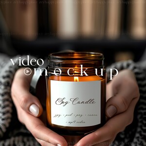 May include: A brown glass jar candle with a white label that reads "Soy Candle" and "jpg, psd, png, canva, .mp4 video". The candle is lit and the flame is visible.