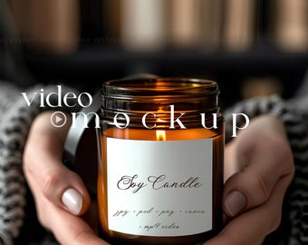 May include: A brown glass jar candle with a white label that reads "Soy Candle" and "jpg, psd, png, canva, .mp4 video". The candle is lit and the flame is visible.