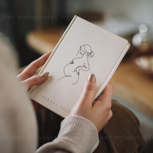 May include: A white journal with a line drawing of a pregnant woman on the cover. The journal says "JOURNAL 2025" on the bottom.