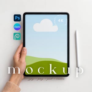 May include: A black tablet with a white stylus, held by a person. The tablet displays a cloud and green hills on a blue background. The word "mockup" is written across the bottom of the tablet. Icons for Photoshop, Canva, and PicMonkey are in the upper left.