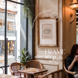 K&ouml;nnte beinhalten: Ein goldfarbener Rahmen mit einem wei&szlig;en Passepartout, der eine Schwarzwei&szlig;illustration einer Tasse Tee zeigt. Der Text "love, tea, eat" ist unter der Illustration gedruckt. Der Rahmen h&auml;ngt an einer Wand in einem Caf&eacute;-Ambiente.