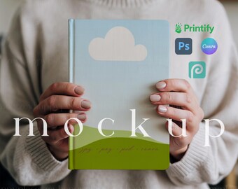Puede incluir: Una persona está sosteniendo un cuaderno verde y azul con un diseño de nube blanca. El cuaderno tiene el texto "Jpg, Pag, Psd, Canva" en la parte inferior. El cuaderno se está sosteniendo frente a un suéter blanco.