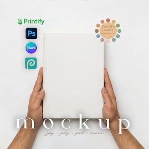 May include: A white book mockup held by two hands. The word "mockup" is displayed in a serif font at the bottom. The image also includes the logos for Printify, Photoshop, Canva, and a design platform, along with the text "jpg + png + psd + canva".