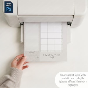 May include: A printed weekly meal planner with a shopping list section. The planner is being printed from a white printer. The text on the planner includes "Weekly Meal Planner", "Shopping List", and days of the week.