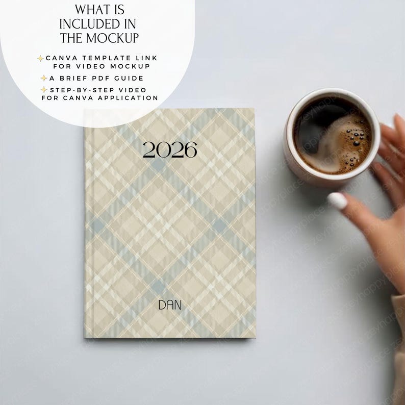 May include: A hardcover planner with a beige, blue, and white plaid pattern. The year "2026" is printed in black at the top, with the name "DAN" below. A cup of coffee sits next to the planner.