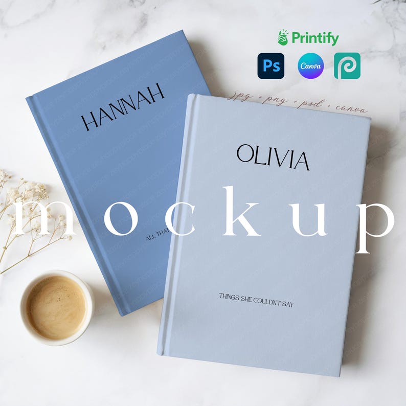 May include: Two hardback books, one light blue and one periwinkle, with the names "HANNAH" and "OLIVIA" printed in black. The book on the right has the text "THINGS SHE COULDN'T SAY". A cup of coffee and sprigs of dried flowers are also visible.