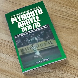 Puede incluir: Un libro verde y blanco titulado "A Season to Remember Plymouth Argyle 1974/75" con el texto "A match by match account of Plymouth Argyle's 1974/75 Division Three promotion-winning season" y "with Neil Fissler". La portada presenta una foto en blanco y negro de un jugador de fútbol en acción.