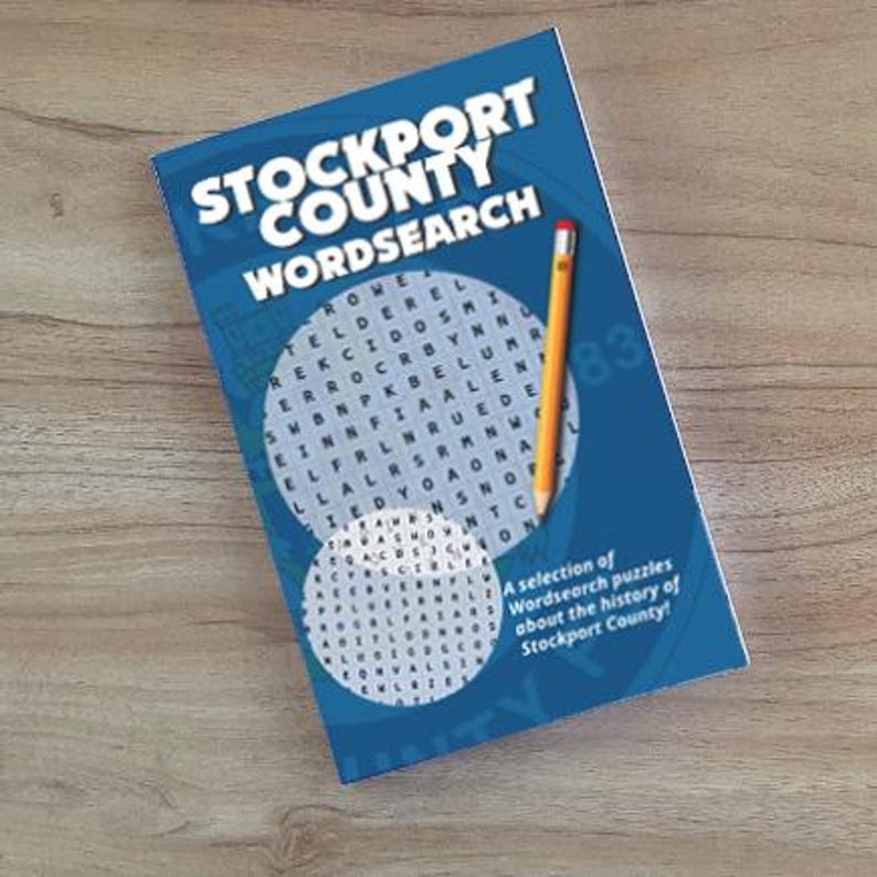 Puede incluir: Un libro azul titulado "STOCKPORT COUNTY WORDSEARCH" con un l&aacute;piz. El libro presenta rompecabezas de b&uacute;squeda de palabras sobre la historia del condado de Stockport. La portada tiene dos cuadr&iacute;culas circulares de b&uacute;squeda de palabras.
