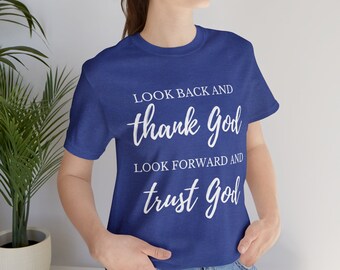 Pode incluir: Uma camiseta azul royal com texto branco que diz "Olhe para trás e agradeça a Deus. Olhe para frente e confie em Deus."