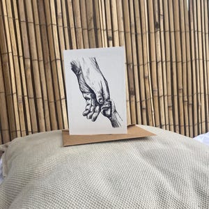 Kinder hand in volwassen hand, dubbele kaart rechtopstaand met envelop, zonder tekst. print van inkt tekening door Krista Kitsz Art