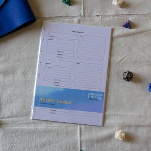 Könnte beinhalten: Ein weißes A5 NPC Tracker Papierblatt mit schwarzem Text und Linien, das unten ein blaues Verlaufsbanner mit dem Text A5 NPC Tracker und aurors mancy gaming aufweist. Das Blatt hat gelochte Ränder an der linken Seite zur Ablage.