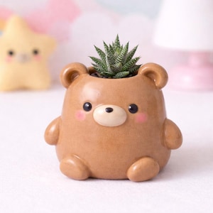 May include: A set of three ceramic mugs with a speckled, matte finish. The mugs are in shades of cream, light gray, and dark gray. Each mug has a simple, minimalist design and a rounded handle. Perfect for coffee or tea.