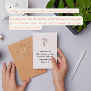 May include: A white card with a question mark drawn on it. The card has text that reads 'Quels sont les objectifs que je veux atteindre dans les cinq prochaine années ?' The card is being held by a hand.