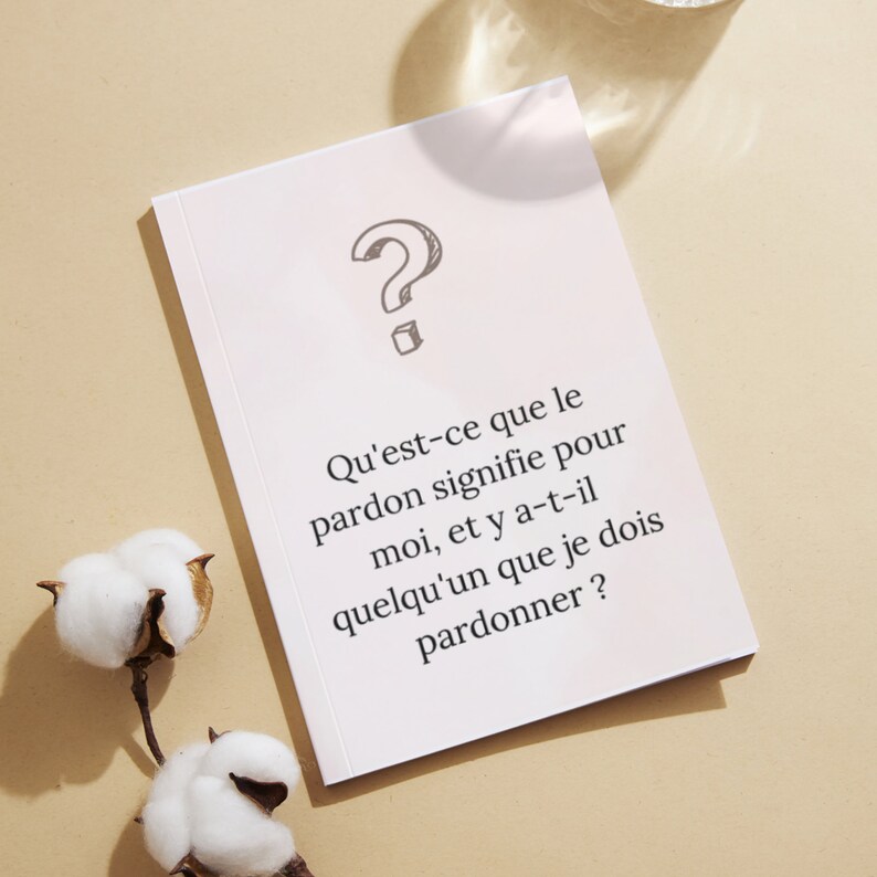 May include: A white card with a question mark drawn on it. The card has text that reads: 'Qu'est-ce que le pardon signifie pour moi, et y a-t-il quelqu'un que je dois pardonner?'