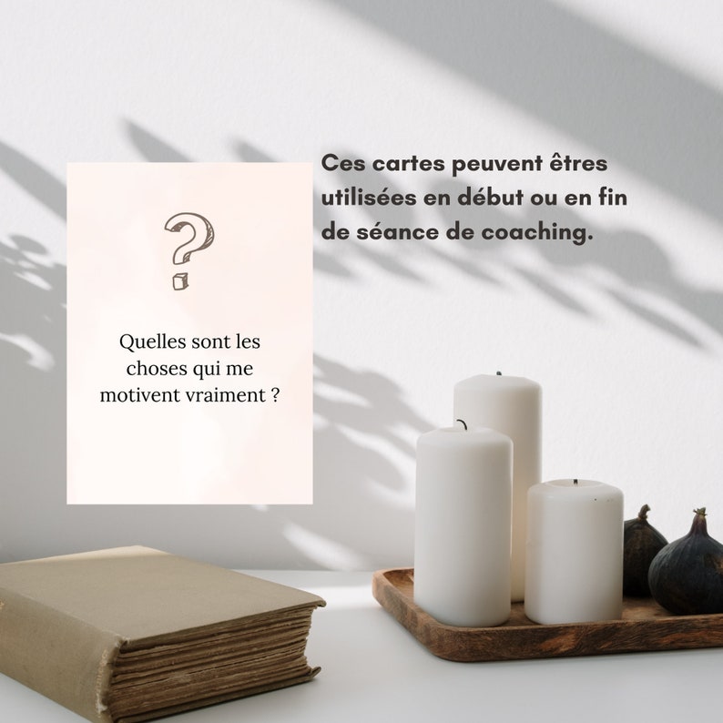 May include: A white card with a question mark and the text 'Quelles sont les choses qui me motivent vraiment?'  Three white candles on a wooden tray with three dark green figs. The text 'Ces cartes peuvent êtres utilisées en début ou en fin de séance de coaching.' is visible above the candles.