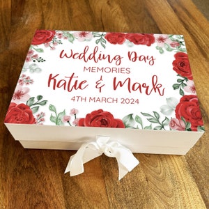 Confezione regalo con cesto di ricordi personalizzato per il giorno del matrimonio con rose rosse e ricordi