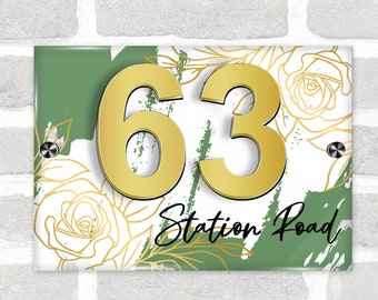 May include: A green and white house number sign with gold floral accents and the numbers 63. The sign also includes the text "Station Road".