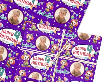 May include: Purple birthday wrapping paper featuring a repeating pattern of cartoon clowns, balloons, and stars. The design includes the text "Happy 4th Birthday" and a photo of a young girl named Natalie. Tied with twine.