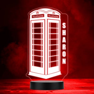 May include: A white 3D printed night light shaped like a red British telephone box with the word "TELEPHONE" on each side. The name "SHARON" is printed vertically on the right side of the box.