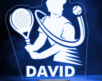 May include: A white silhouette of a person playing paddle tennis with a paddle and a ball. The name "DAVID" is written below the silhouette. The image is a 3D printed night light.