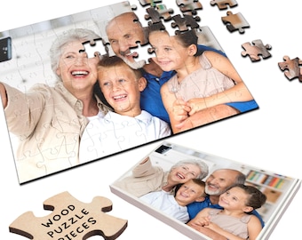 Op de afbeelding: Een gezin van vier, twee volwassenen en twee kinderen, lachen en maken een selfie. De foto is afgedrukt op een houten puzzel met de woorden "Wood Puzzle Pieces" op een puzzelstuk op de voorgrond.