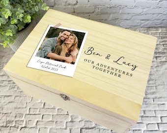 May include: A wooden keepsake box with a photo of a couple and the text "Ben & Lucy Our Adventures Together" on the lid. The photo is from Elan Valley National Park, Wales, 2023.