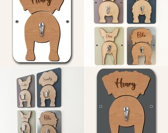 May include: Set of six wooden dog butt hooks with names "Henry", "Cookie", "Sandy", "Elvis", "Rolo" engraved on the top. Each hook is mounted on a different colored background: white, gray, brown, green, silver, and dark gray.