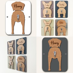 May include: Set of six wooden dog butt-shaped hooks with personalized names. The hooks are in various colors, including white, gray, brown, and green. Each hook has a silver metal hook for hanging items.