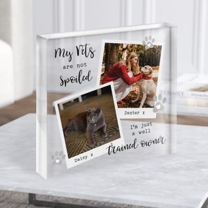 May include: A clear acrylic block with two photos of pets. The top photo shows a woman with a dog. The bottom photo shows a cat. The text "my pets are not spoiled" is at the top of the block. The text "Daisy x" and "Dexter x" are below the photos. The text "I'm just a well trained owner" is at the bottom of the block.
