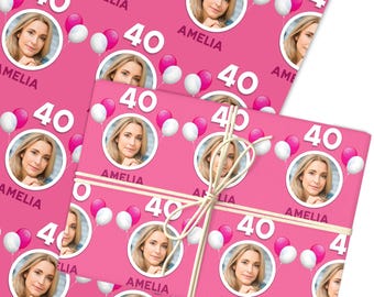 May include: Pink wrapping paper featuring a repeating pattern of a woman's photo, the number 40, and balloons. The name "AMELIA" is also printed on the paper. Tied with twine.