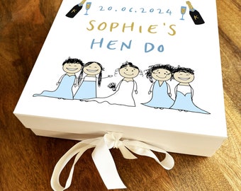 Pode incluir: Caixa de presente branca com uma fita azul. A caixa tem uma ilustração de desenho animado de cinco mulheres em vestidos azuis e brancos. O texto na caixa diz "20.06.2024 Sophie's Hen Do".