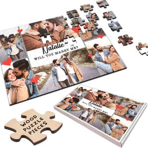 May include: A wooden jigsaw puzzle featuring a collage of photographs of a couple. The puzzle is presented in a white box with the text "Natalie Will You Marry Me?" printed on it. The puzzle pieces are scattered around the box.