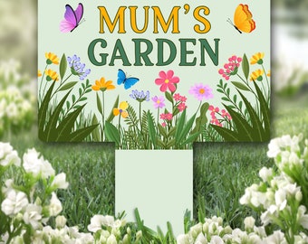 Può includere: Un cartello da giardino verde con il testo "Mum's Garden" in lettere gialle. Il cartello è decorato con fiori e farfalle colorati.