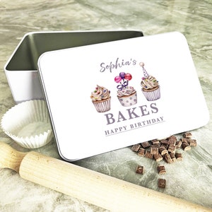 May include: White metal tin with a colourful cupcake design and the text "Sophia's Bakes Happy Birthday".