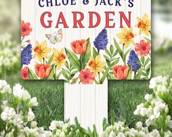 Può includere: Un cartello da giardino in legno bianco con il testo "Chloe & Jack's Garden" in lettere blu e rosse. Il cartello è decorato con un bordo floreale ad acquerello con narcisi gialli, tulipani rossi, giacinti blu e una farfalla.