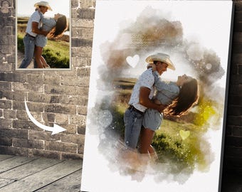 May include: A canvas print featuring a watercolor-style image of a couple embracing outdoors. The image is surrounded by a soft, blurred watercolor effect with heart accents. A smaller framed photo is also visible.