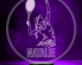 Op de afbeelding: Een witte omtrek van een tennisspeler met een racket in een cirkel op een paarse achtergrond. De naam "NATALIE" staat onder de speler.