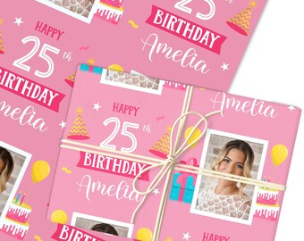 May include: Pink birthday wrapping paper with the text "Happy 25th Birthday Amelia". The design includes a photo, party hats, balloons, and a cake. The wrapped gift is tied with twine.