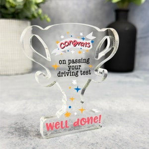 May include: A clear acrylic trophy with a colourful design and the text "Congrats on passing your driving test Well done!"