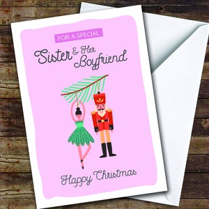 May include: A Christmas card with a pink background and a white envelope. The card features a ballerina and a nutcracker hanging from a green branch. Text on the card reads "For a Special Sister & Her Boyfriend" and "Happy Christmas."