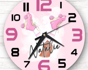 Pode incluir: Relógio rosa e branco com ponteiros pretos e números rosa. O relógio apresenta um design de patins com o nome "Natalie" escrito no mostrador.