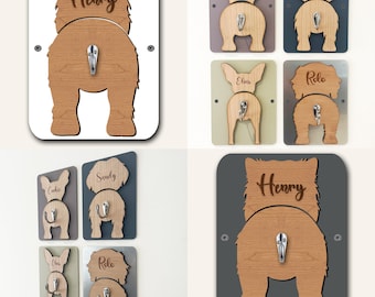 Puede incluir: Llaveros de madera con forma de perro con un gancho para colgar llaves. Los llaveros son de varios colores y presentan diferentes nombres de perros. Un llavero tiene grabado el nombre "Henry".