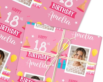 May include: Pink wrapping paper with a photo, text, and illustrations for an 18th birthday. The text reads "Happy 18th Birthday Amelia". The design includes a photo, cake, party hats, and balloons.