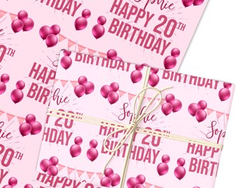 以下が含まれることがあります： ピンク色の誕生日の包装紙。マゼンタ色の風船と「Happy 20th Birthday Sophie」の文字がプリントされています。 包装されたギフトは、自然な麻ひもで結ばれています。