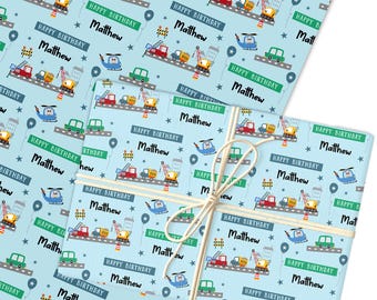 May include: Light blue wrapping paper featuring a repeating pattern of vehicles, buildings, and the text "Happy Birthday Matthew." The design includes cars, helicopters, and construction vehicles. Tied with twine.